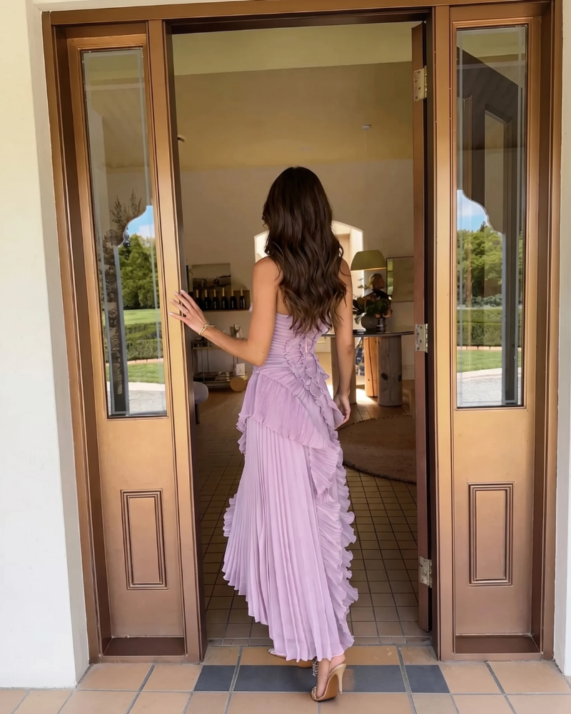 Back view of lavender pleated maxi dress with corset lace-up back and cascading ruffle trim