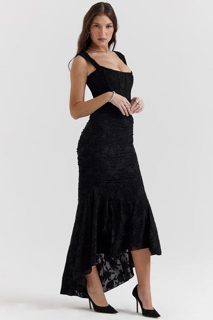 Angled side view of black corset midi dress showing structured bodice, ruching, and high-low skirt