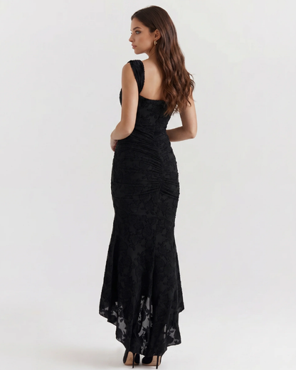 Back view black corset midi dress with ruched center seam, wide straps and high-low skirt