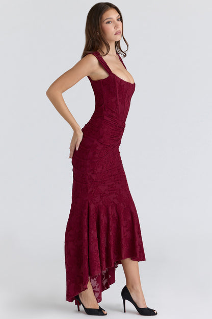 Side view burgundy corset midi dress with structured bodice seams, ruched skirt, flared hem