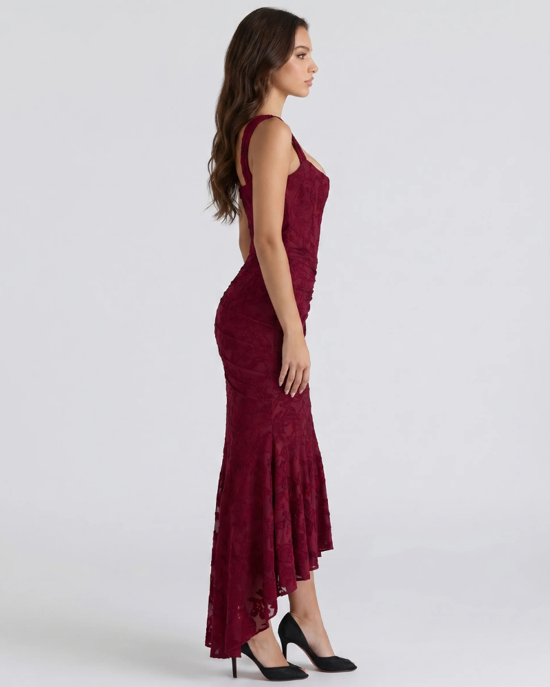 Side view of burgundy corset midi dress with fitted lace bodice, ruched skirt and high-low hem