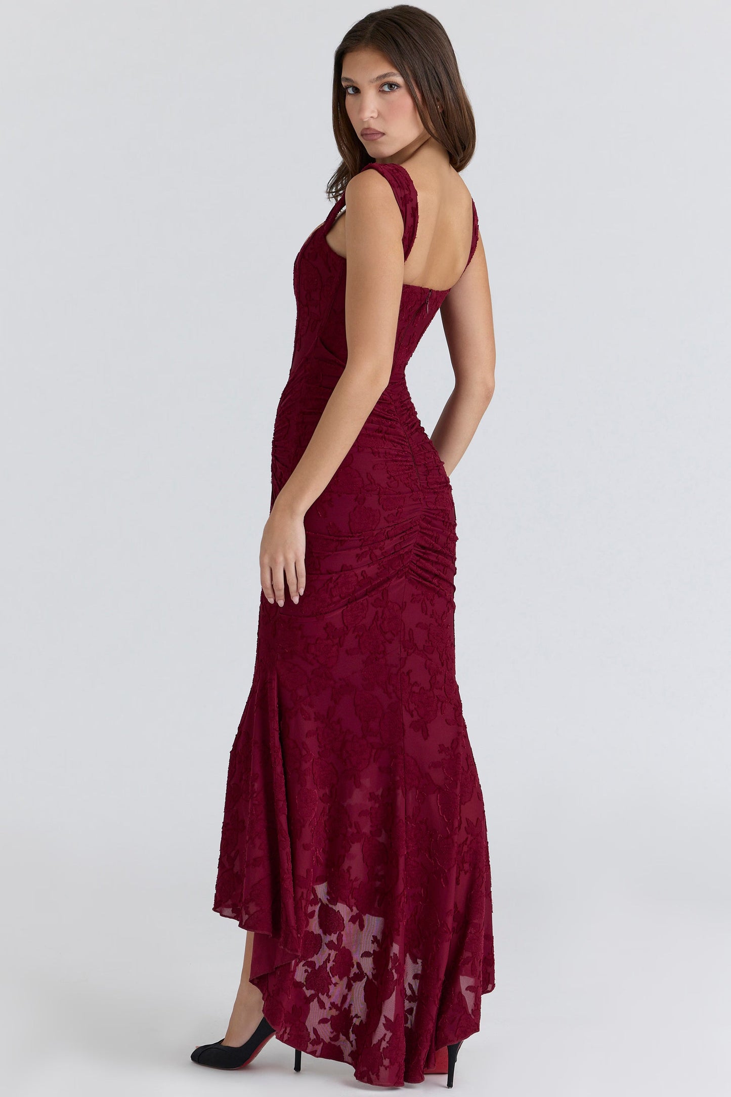 Three-quarter back view of burgundy corset midi dress with fitted silhouette and high-low hem