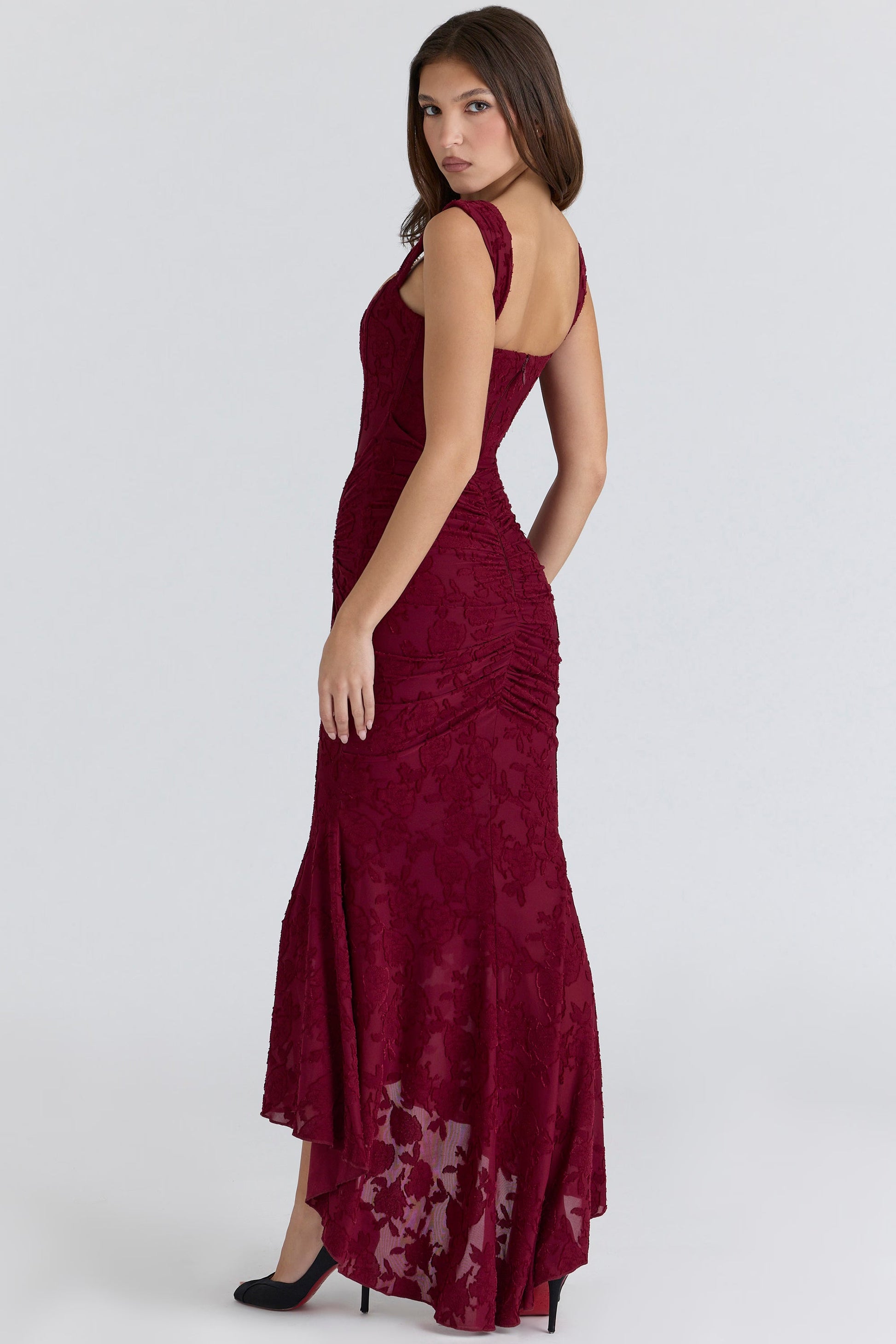 Three-quarter back view of burgundy corset midi dress with fitted silhouette and high-low hem