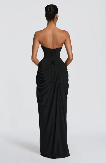 Back view of black strapless ruched maxi dress with lace-up corset back and gathered skirt