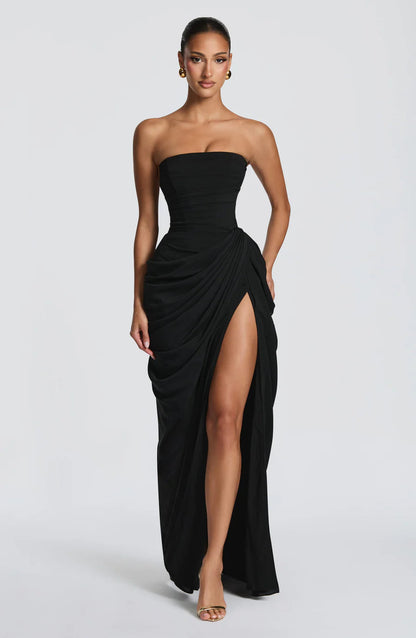 Black strapless ruched maxi dress with draped skirt and high thigh slit, front view