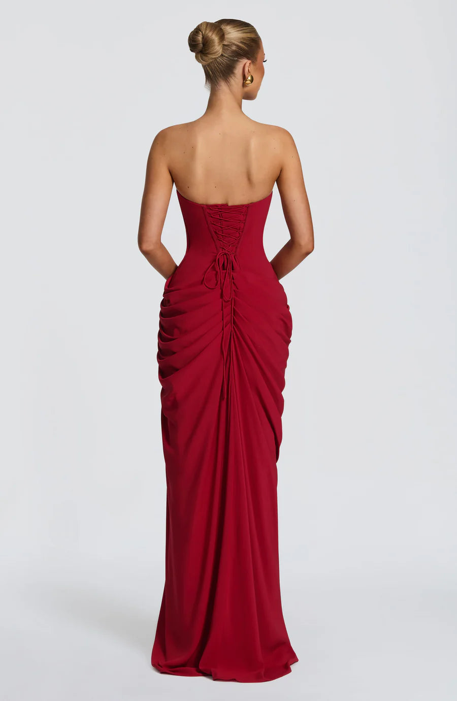 Back view of red strapless maxi dress with lace-up corset back and gathered ruched skirt