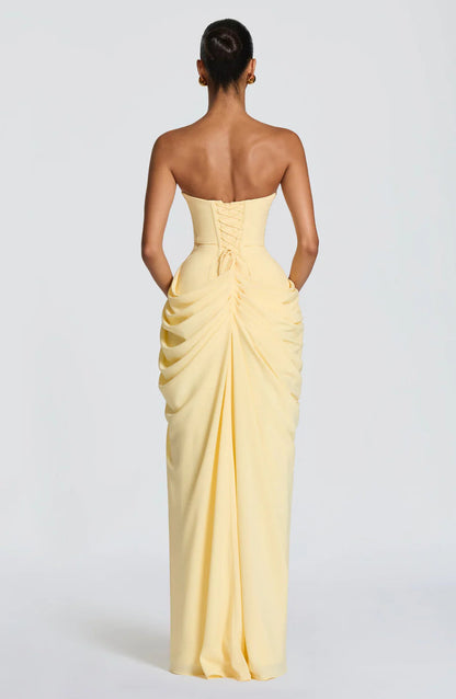 Back view of yellow ruched maxi dress showing lace-up corset back and gathered skirt detail