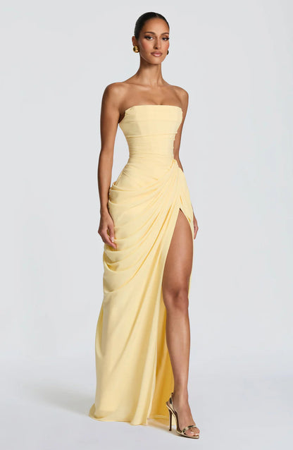 Three-quarter view of yellow strapless ruched maxi dress with drape ruching and thigh-high slit
