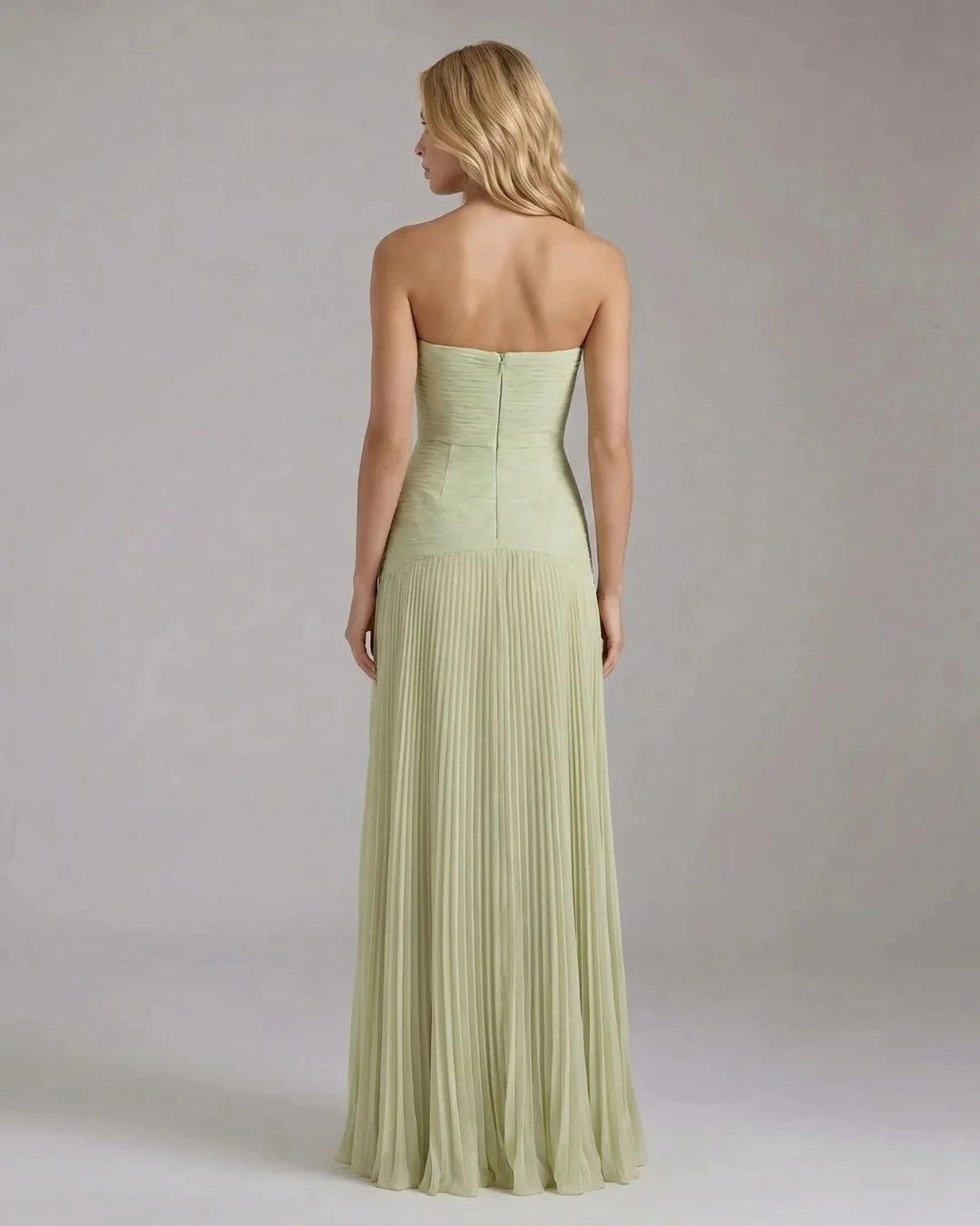 Back view of sage green strapless maxi dress with center zipper and pleated floor-length skirt