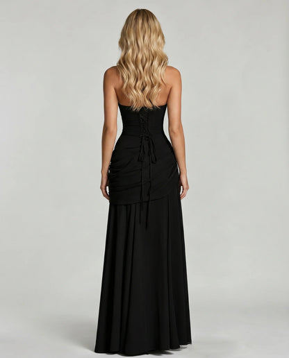 Back view of black ruched maxi dress with lace-up corset detail and long tie at center back
