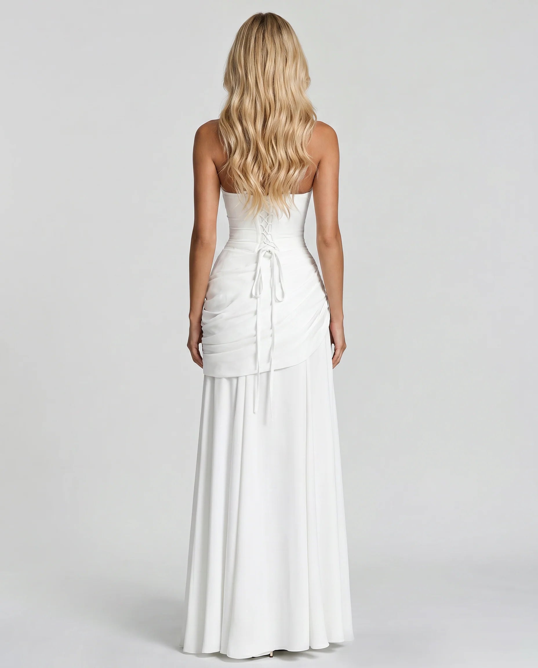 Back view of white ruched maxi dress with lace-up corset tie and flowing skirt