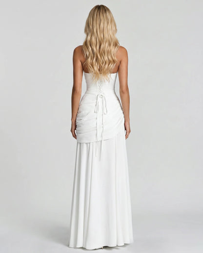 Back view of white ruched maxi dress with lace-up corset tie and flowing skirt