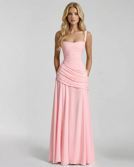 Front view of blush pink ruched maxi dress with square neckline, wide straps, and draped skirt