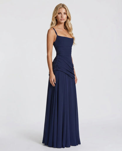 Side view of navy ruched maxi dress with fitted bodice and flowing floor-length skirt
