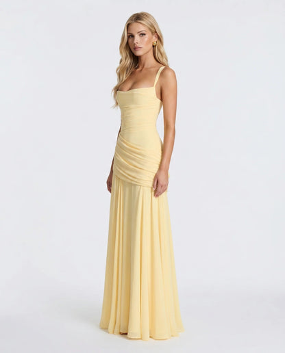 Side view of yellow ruched maxi dress showing bodycon fit through hips and soft draped maxi skirt
