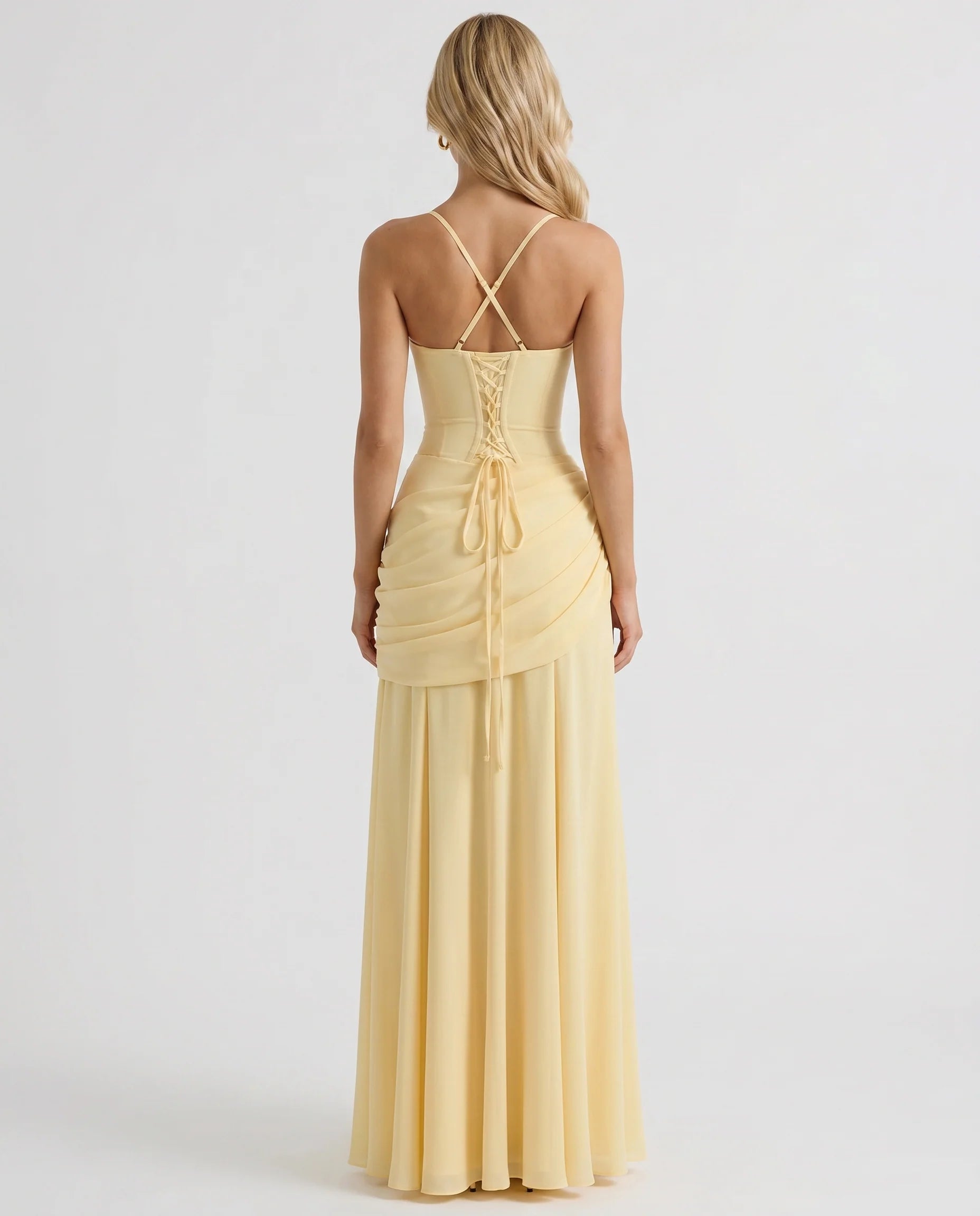 Back view of yellow ruched maxi dress with crisscross straps and lace-up corset detail at center back