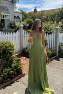 Green corset maxi dress with fitted bodice and pleated skirt, angled front view in garden
