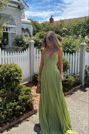 Back view of olive green corset maxi dress with low back and long draped skirt outdoors