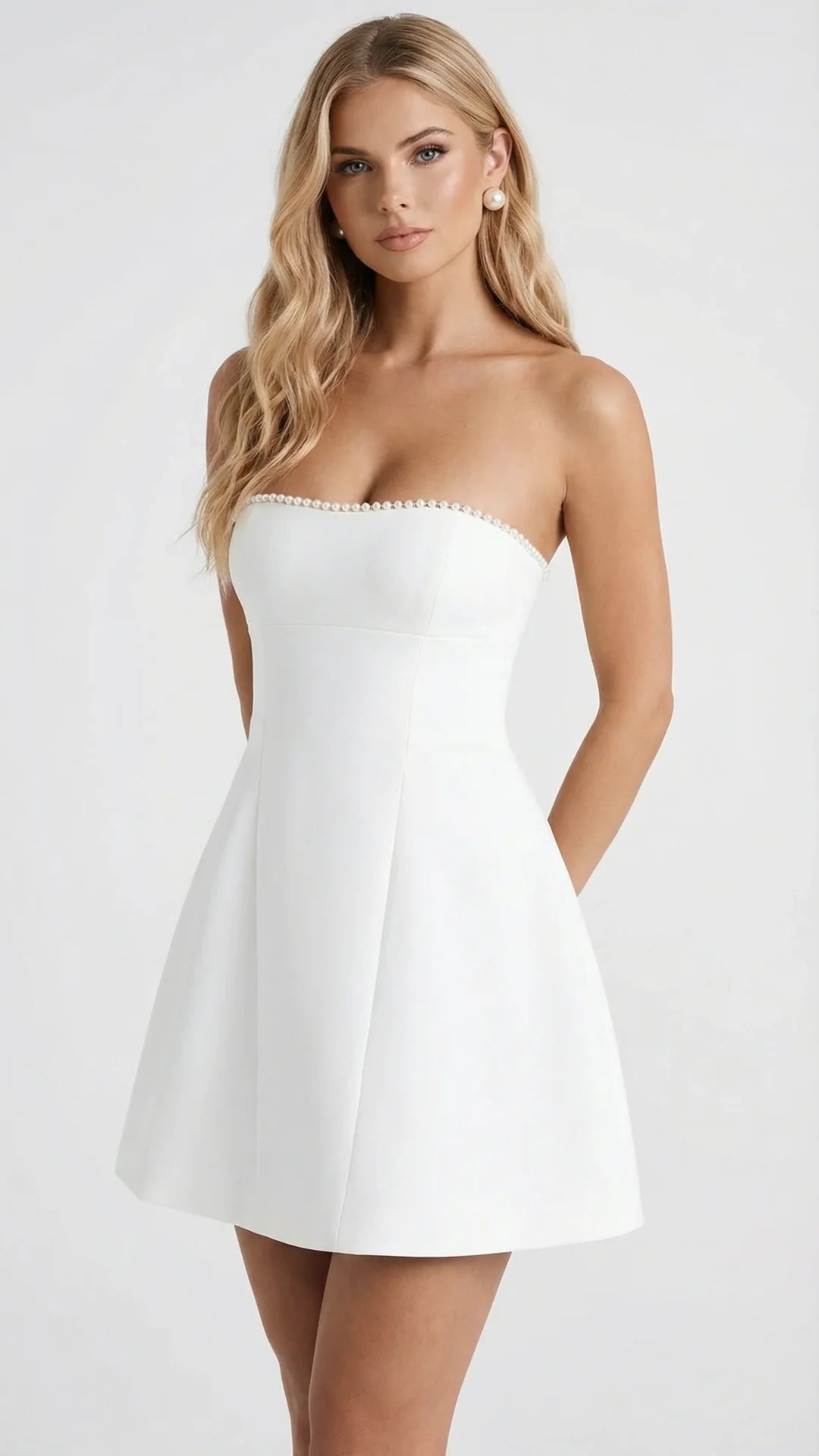 Angled front view of white pearl-trim strapless mini dress with A-line skirt silhouette