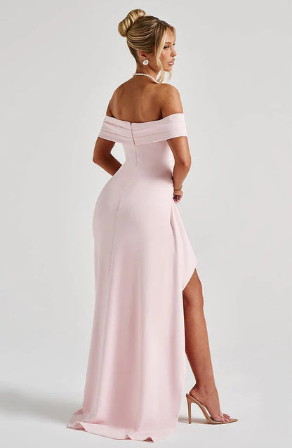 Three quarter back view of pink ruched maxi dress showing off shoulder neckline and side slit