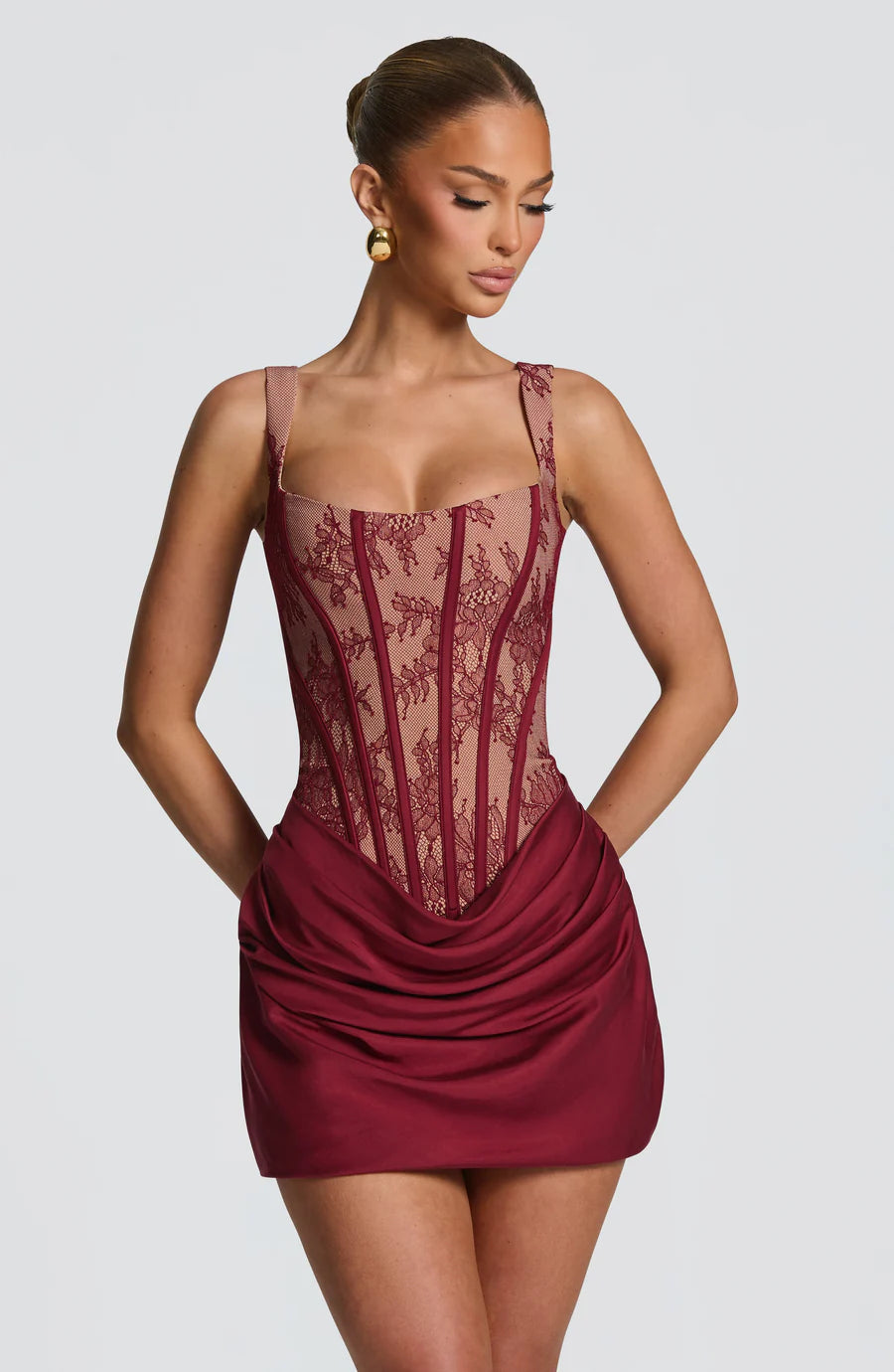 Burgundy lace corset mini dress front view with sweetheart neckline, sheer lace panels, and draped skirt