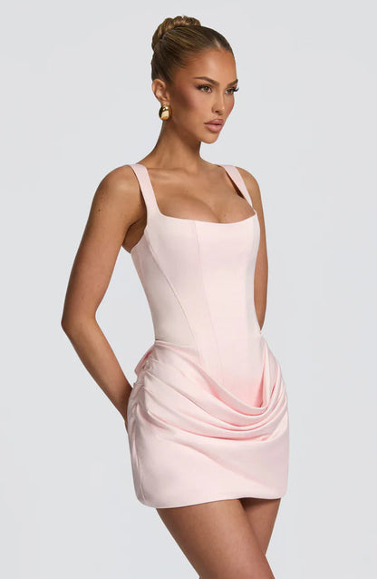Side angle of light pink corset mini dress with wide straps and ruched drape detail