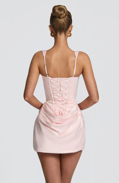 Back view of light pink corset mini dress featuring lace-up panel and adjustable straps