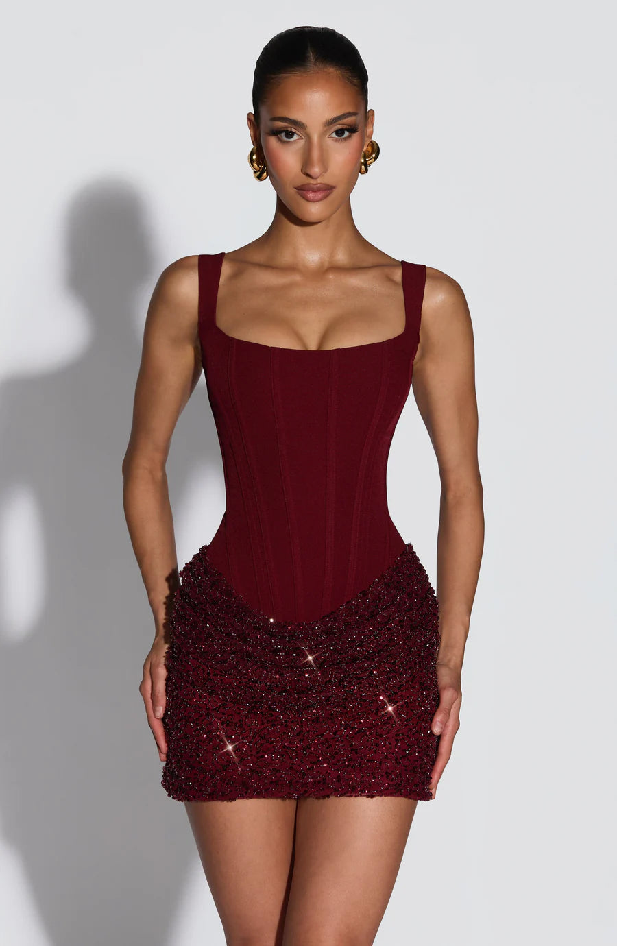 Red sequin corset mini dress with square neckline, wide straps, and fitted boned bodice