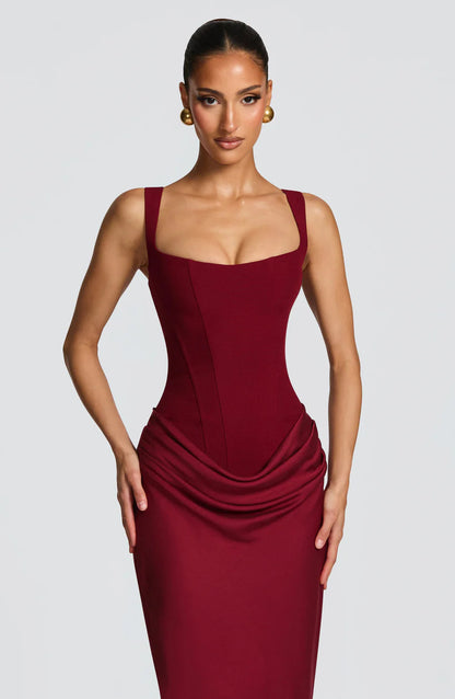 Close-up of burgundy corset-style bodice with square neckline and gathered drape at hips