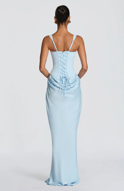 Full-length studio back view of light blue draped maxi dress with lace-up corset and tie at waist