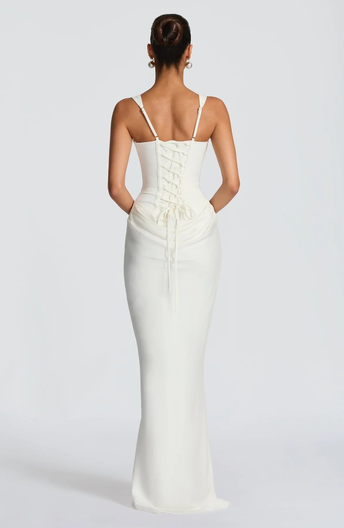Back view of white draped maxi dress with adjustable straps, lace-up corset back and gathered detail