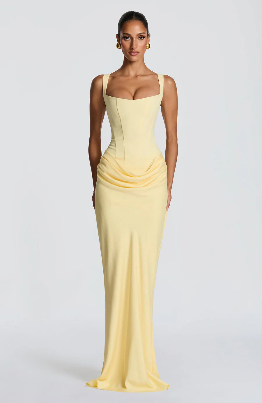 Pale yellow draped maxi dress with square neckline and corset bodice, floor-length hem